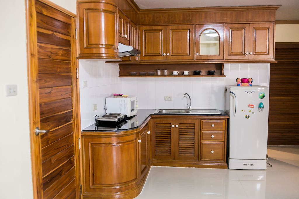 This kitchen is fully stocked with everything you could need to cook with. It has a microwave, stove, cooking fan and basic spices.