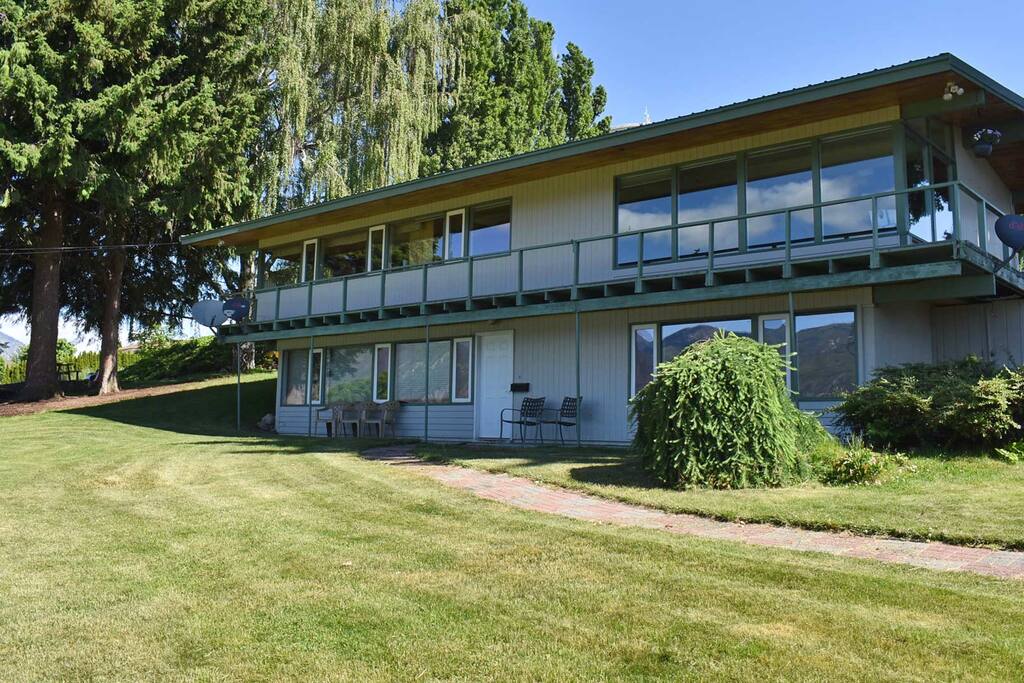 Back side of house with large grassy yard and many windows facing the beautiful views!