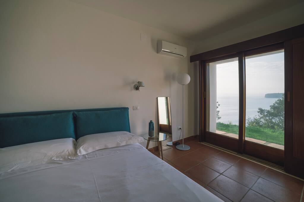 Camera elegante vista mare, dotata di letto matrimoniale, con bagno privato. Pavimento in cotto Toscano pregiato e accesso diretto al giardino.