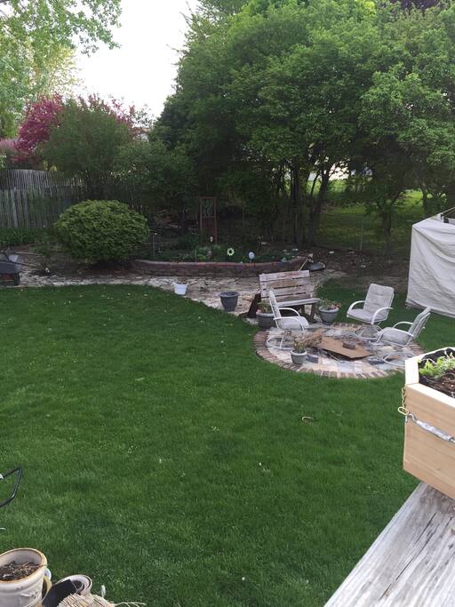 Fire pit with lots of seating. Screened in swing behind.