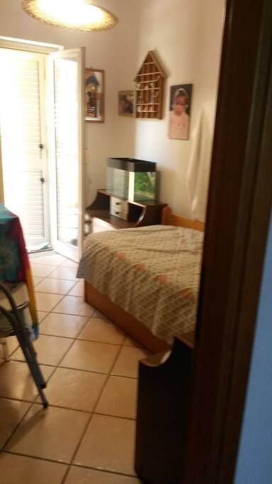 seconda stanza da letto con un letto singolo, cassettiera, comodino e balcone retro.