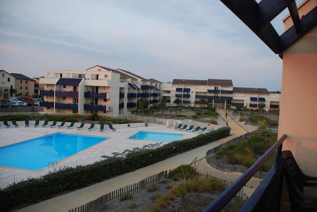 Vue du balcon sur la piscine privée de la résidence