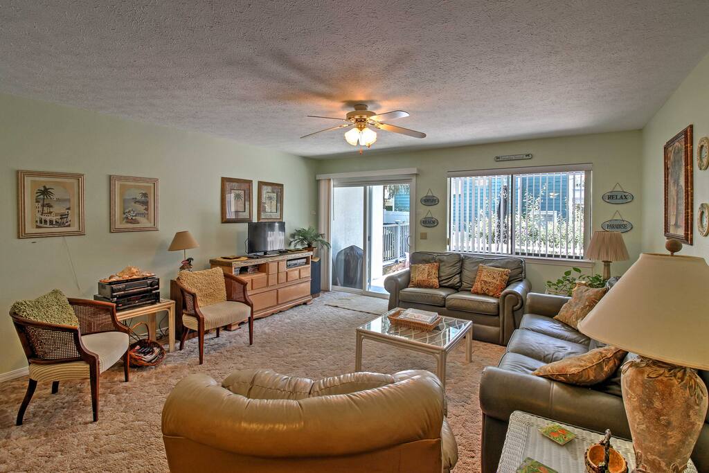 The bright living area features leather furnishings, 2 armchairs & a flat-screen cable TV.