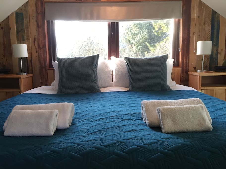 King-sized bed with setting sun behind