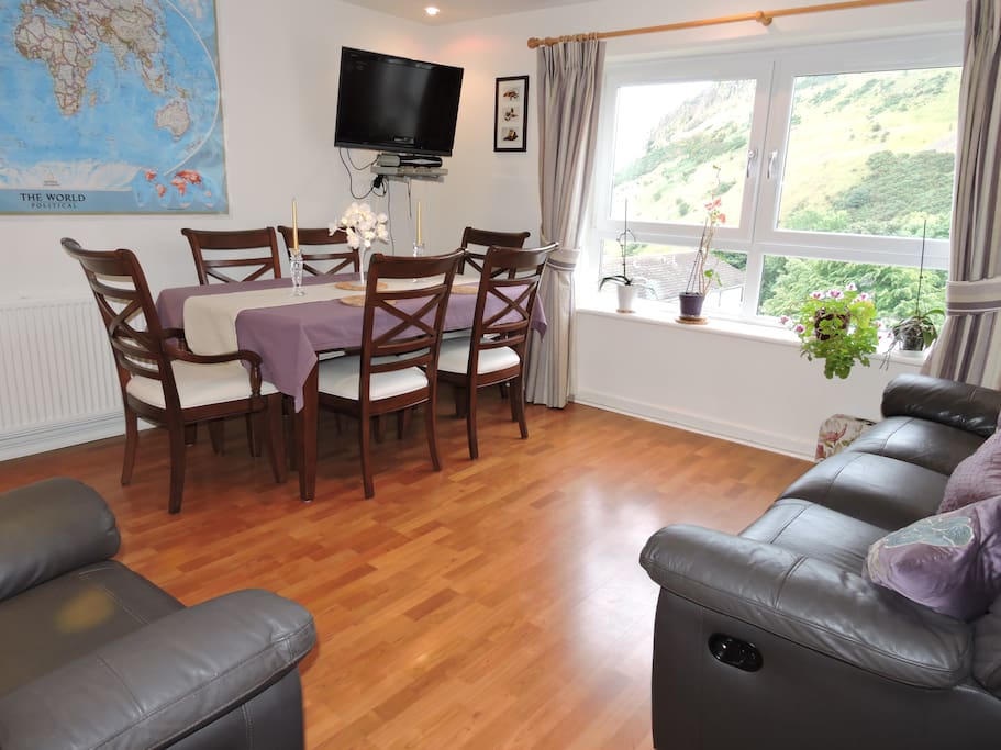 Living room with reclinable chair and sofa, TV and a map of the world to plan your next travels.