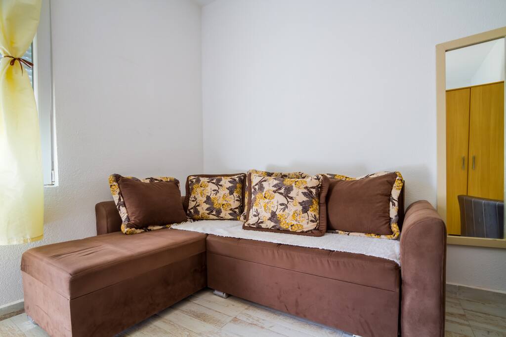 On the other corner, there is a sofa which can be used for both sitting and sleeping purposes.