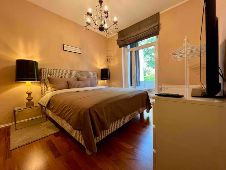 ห้องนอนหมายเลข 4 พร้อมเตียงคู่ขนาด 1 x 180 ซม. พร้อมทีวีในห้องและระเบียงที่มองเห็นสวน