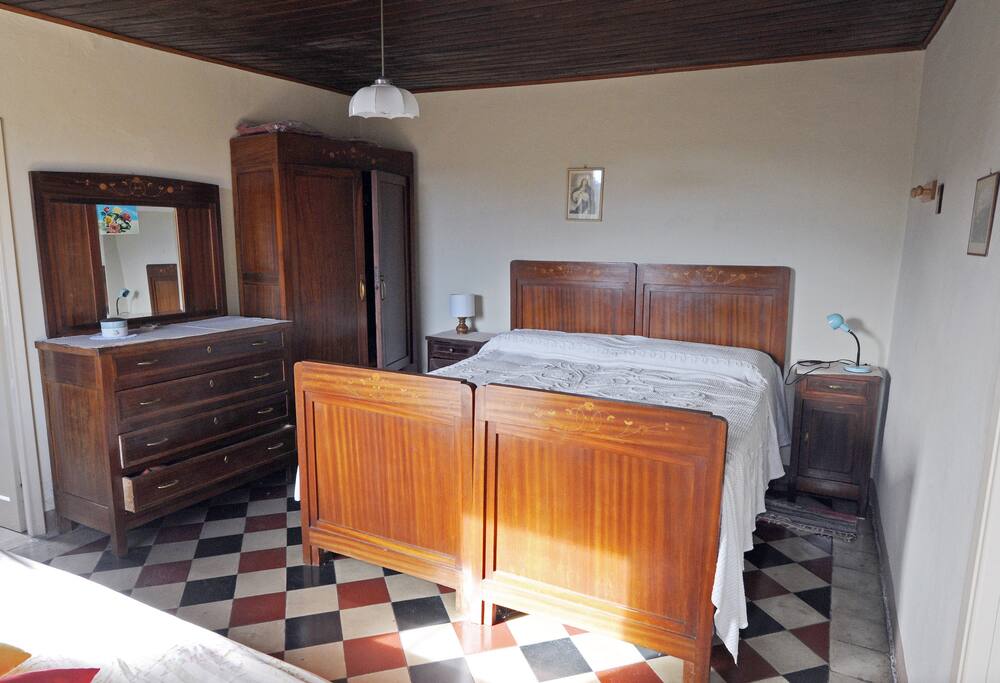 La camera da letto, con l'antico letto di legno, l'armadio e il comò in stile e l'originale pavimento. Sapori d'altri tempi...