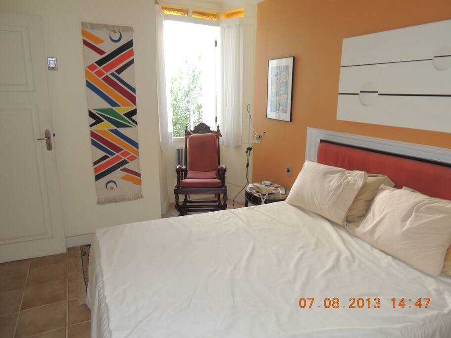Quarto principal, c/cadeira de balanço frente à bay window.