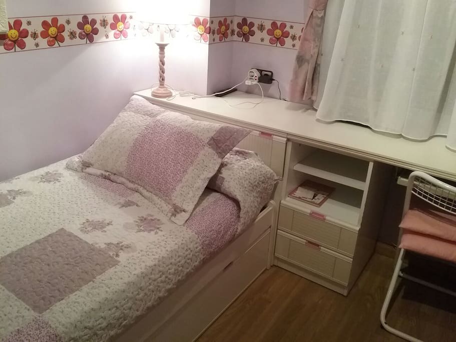 Vista de la cama de la habitación y parte del escritorio.