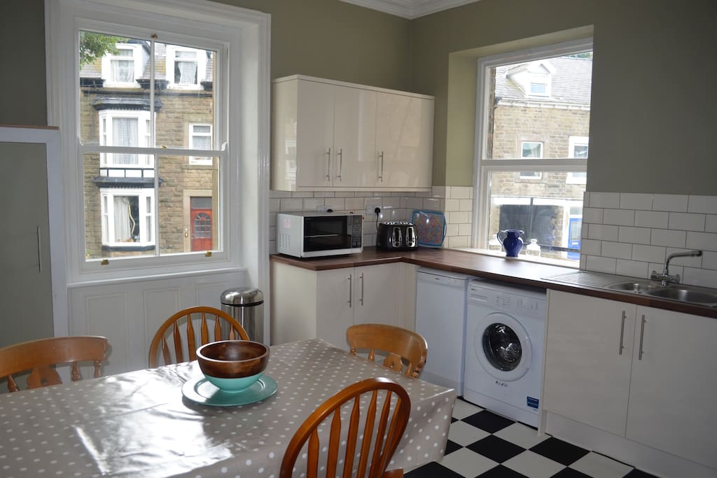 Large kitchen with dining table that easily seats six, washing machine, dishwasher, microwave, toaster, kettle, fridge freezer, electric oven and hob.