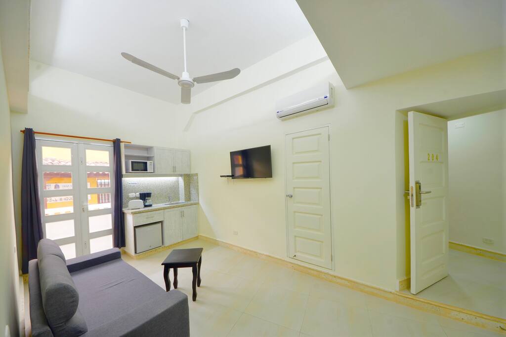 Living area with balcony, kitchenette, sofabed, TV & full bath