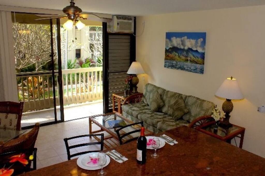 Living room with sofa bed and lanai with garden view