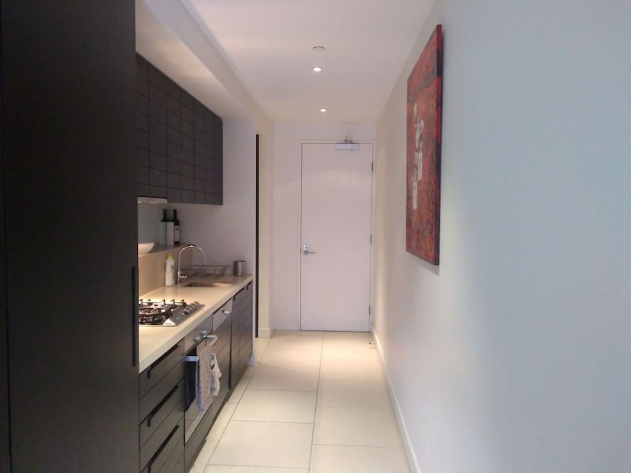 Entrance into modern well equipped galley kitchen
