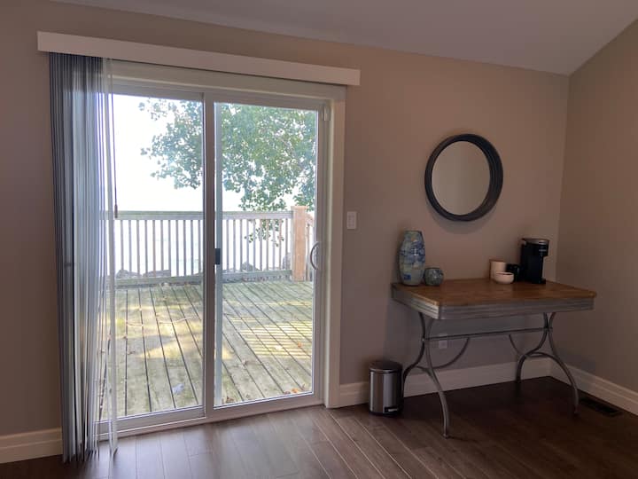 Primary bedroom - King size bed with a view of the lake from your own private deck.  Single cup Keurig and mini fridge allow you to make a coffee and enjoy the morning right from the comfort of your room.