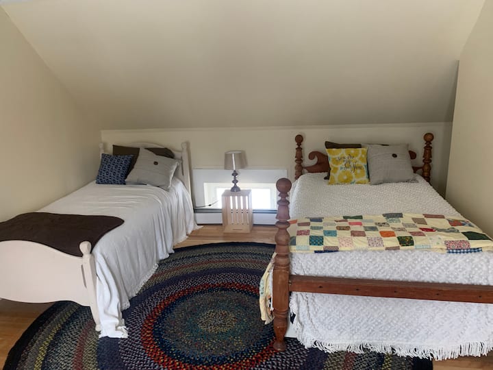 The Middle Room:  This room sleeps 2-4 and has one oversized antique full bed. one twin and a trundle bed beneath the oversized full bed. This room also has a closet and a view of Sunapee's South Peak can be enjoyed from this room as well.