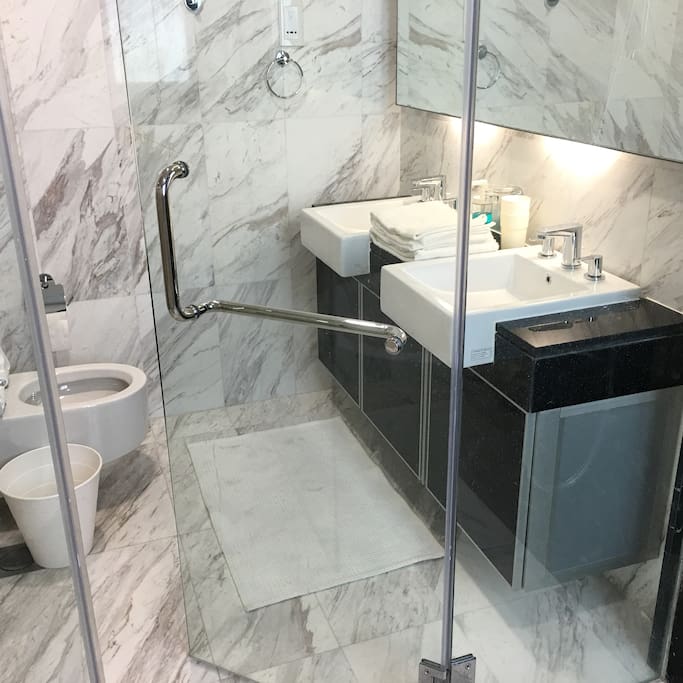 Master bedroom toilet: His and hers sinks located in a marble cocoon
