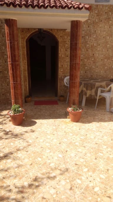 Entrée : vaste cour avec 2 petits jardins, table et des chaises pour profiter du soleil - possibilité animaux mais uniquement dans la cour