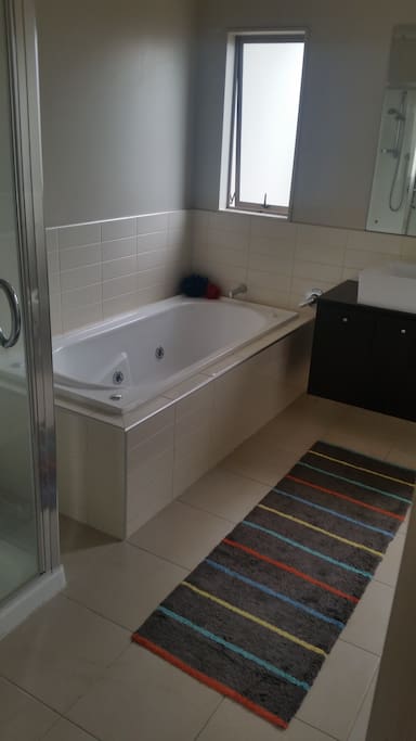 Spa bath and shower with shampoo, conditioner and soap.