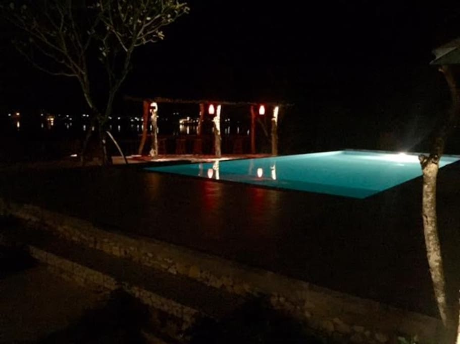 Night time view of the infinity pool and bar area