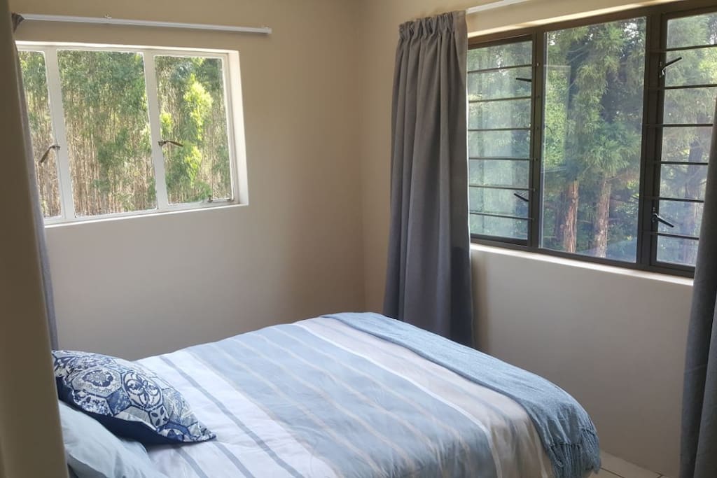 Comfy double bed surrounded by forest views
