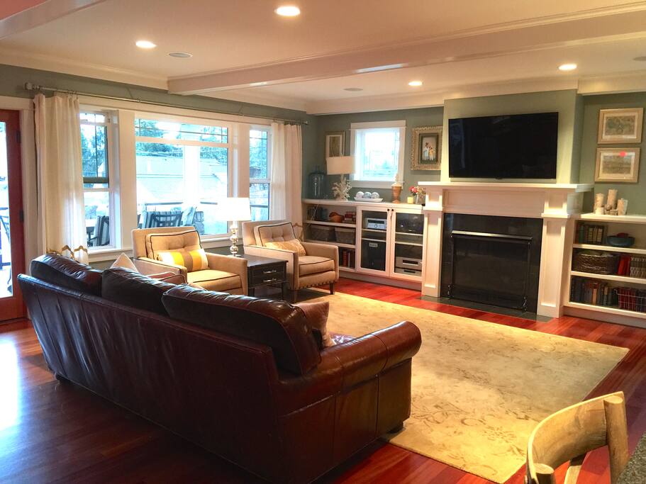 Main floor open concept living room with 55" flat screen TV, Direct TV, Apple TV, and oversized Restoration Hardware Leather couch that can become a Twin bed.