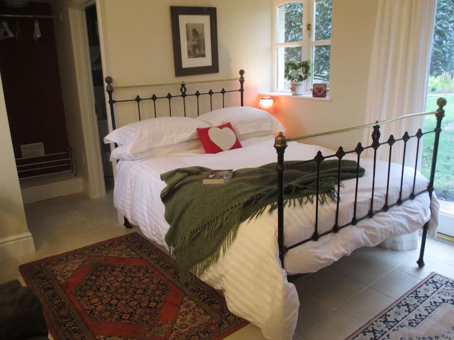 Victorian iron bed with White Company linen and cosy 13.5 tog feather duvet.