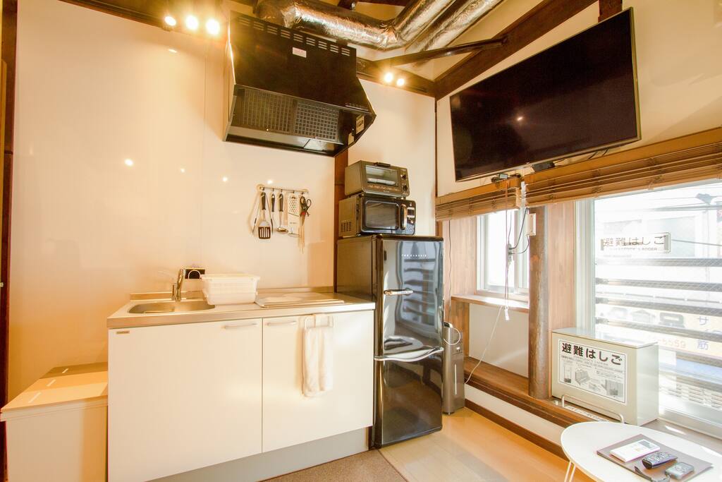 Inside the room there is a big TV and kitchen, fridge and microwave.