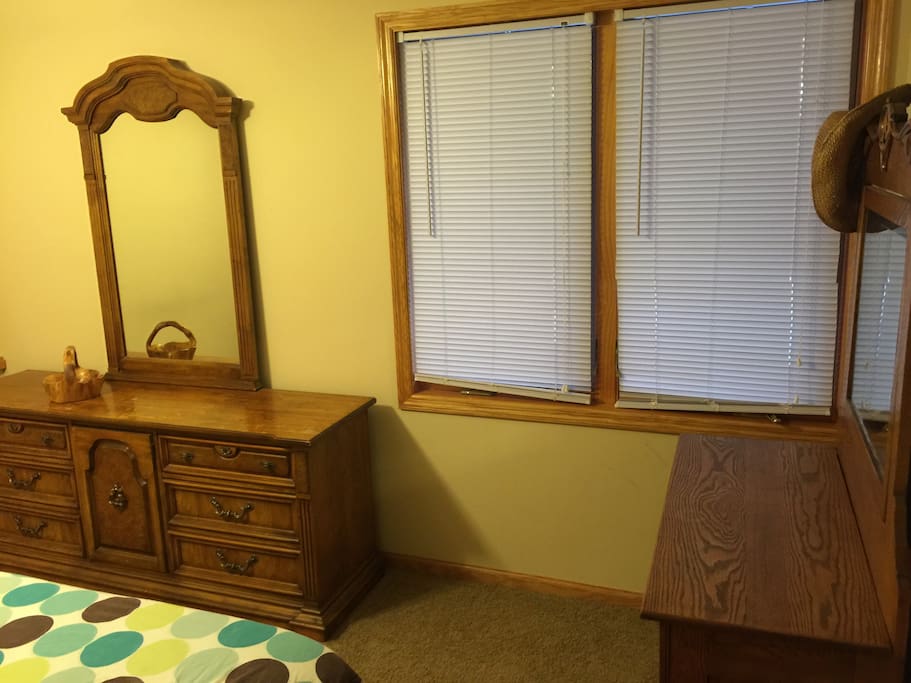 Bedroom mirrors and dressers provide a place to put a suitcase or overnight bag. Close the blinds for privacy or open them to let the sunshine in. Windows look out into the scenic woods.