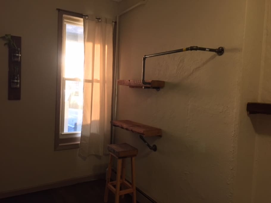desk area with shelving and piping to hang clothes