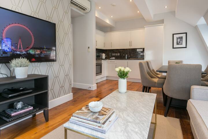 Amplia sala con un interior sofisticado y un televisor grande con el paquete ilimitado de Sky.