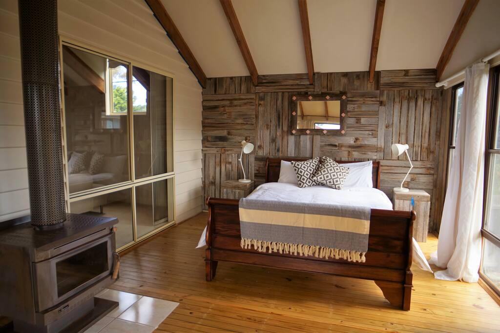 Large studio bedroom with queen sleigh bed and a sitting area.