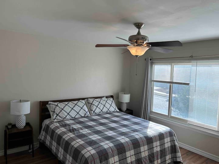 Cama tamaño king en dormitorio principal con vistas a la calle.