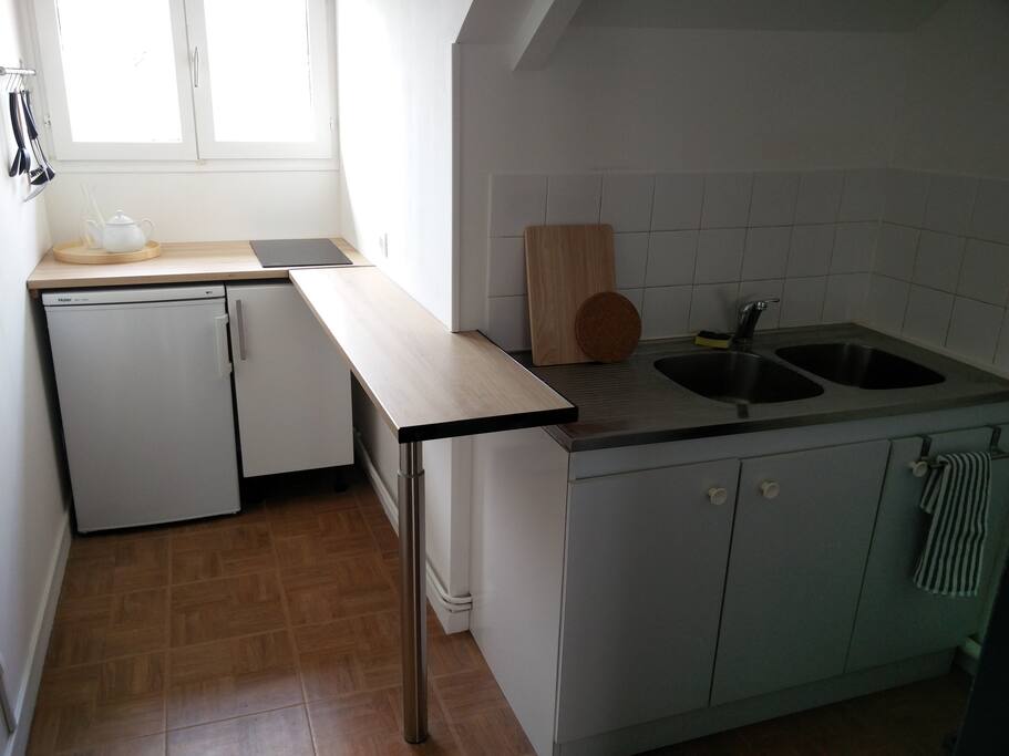 Cuisine ouverte sur le salon, séparée par un bar.