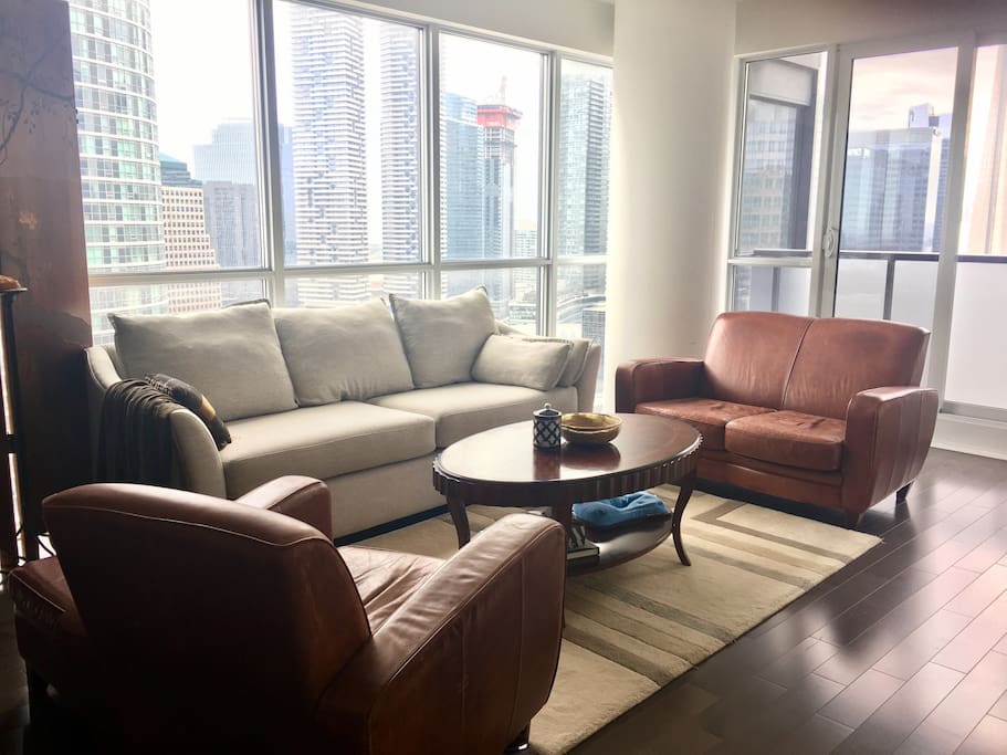 Enjoy spectacular views of CN tower and lakeshore sitting on sofa