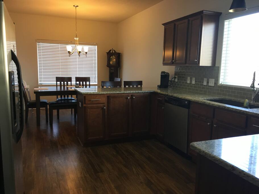 Bright and cheerful kitchen with eating area. Electric stove and oven. Dishwasher and refrigerator. Granite counters.