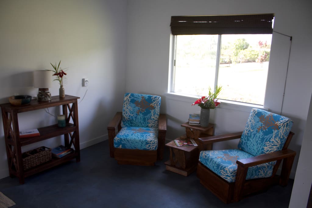 Sitting area, with refinished antique Hawaiian Koa wood chairs and table, stained concrete floors.