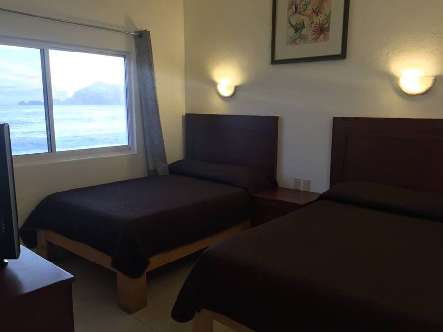 Habitación con dos camas matrimoniales, vista a la playa