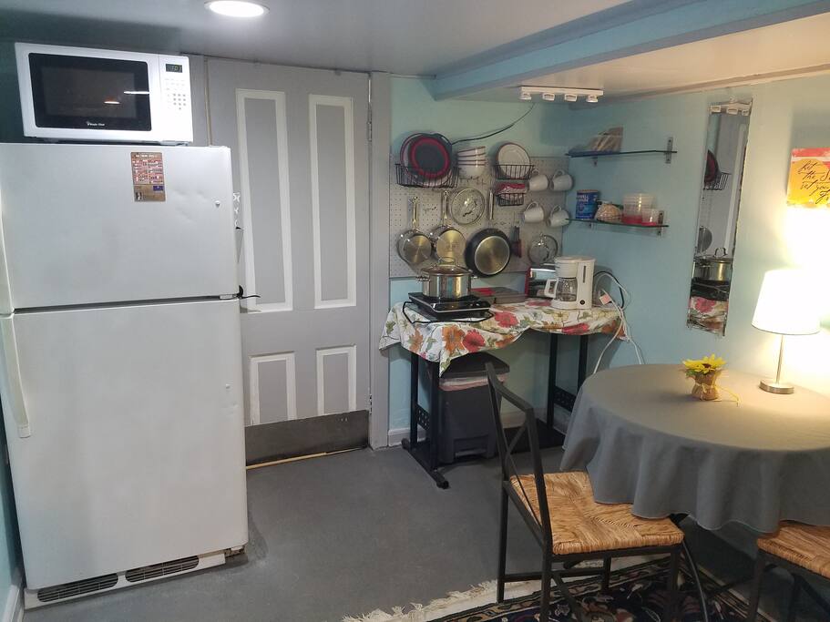 Kitchenette with full size refrigerator, toaster, coffee maker, microwave, and one burner.