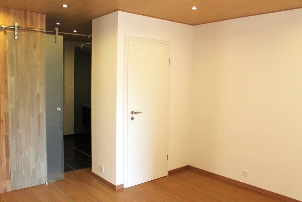 Toilettes séparés et porte vitrée coulissante donnant sur la salle de bain