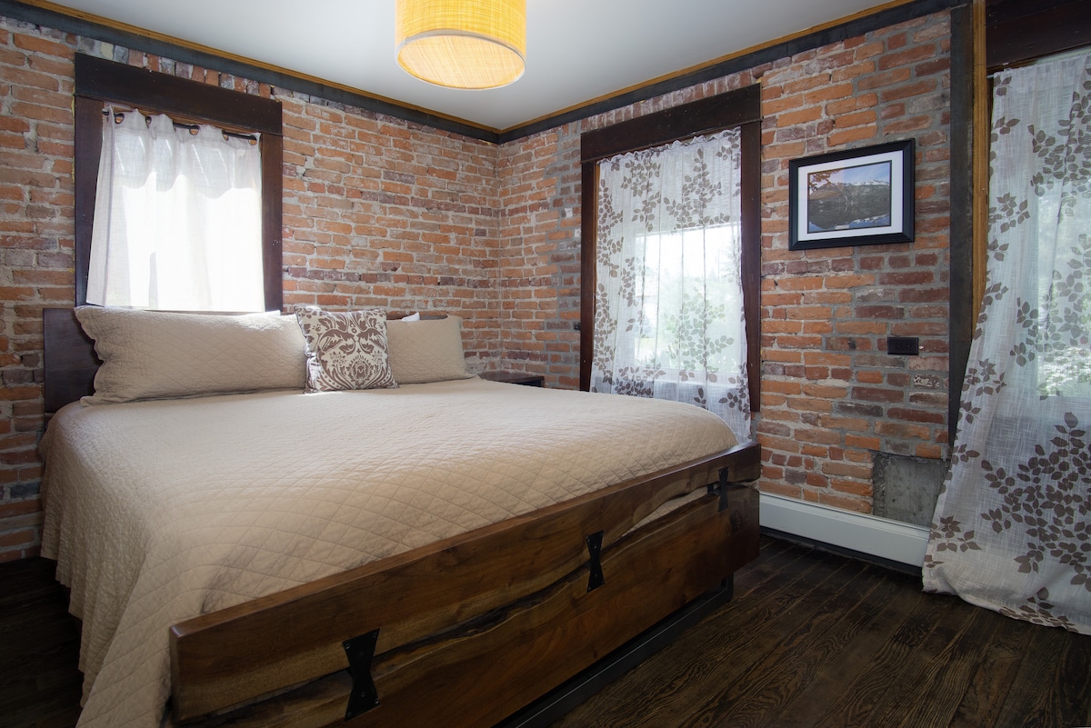 חדר שינה של הבעלים בקומה התחתונה מס '1 עם מיטת קינג סייז שעשויה מעץ בשימוש חוזר