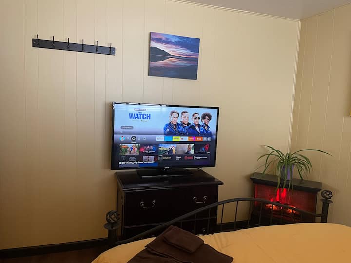 Segundo quarto no andar de baixo com cama queen size, armário, aquecedor de lareira elétrico e smart TV