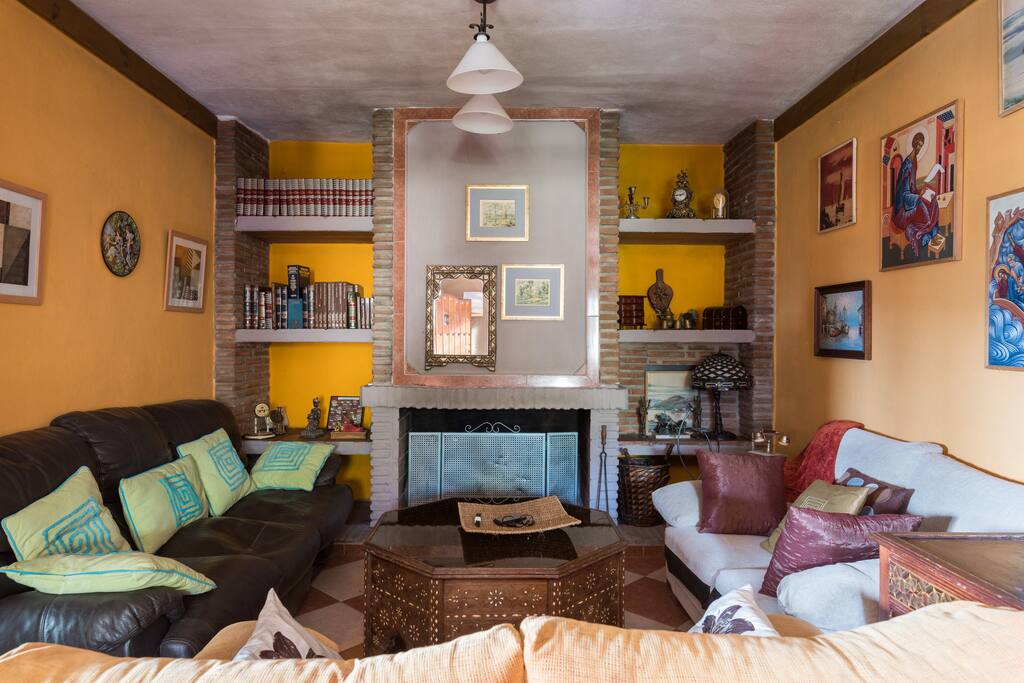 Es el sslon con varios sofas y una gran chimenea