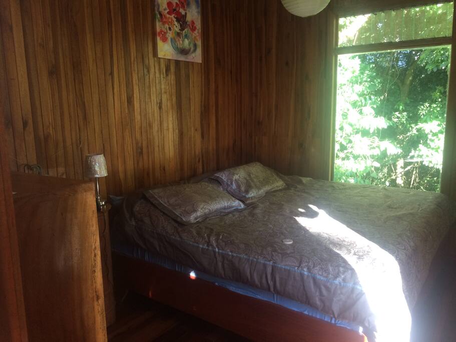 Upstairs master bedroom with king bed, overlooking the forest