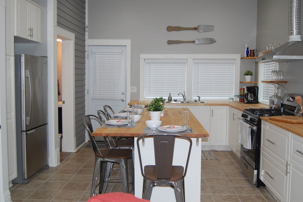 Full kitchen, including cookware, coffee maker, refrigerator and dishwasher, along with an eat-in island