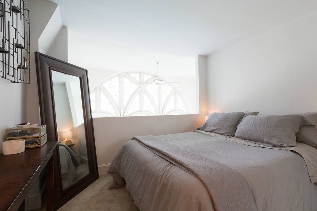 Loft master bedroom overlooks vaulted stained glass ceiling