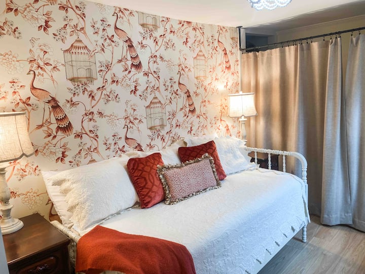 Segundo  dormitorio adyacente al dormitorio principal. La pintura fresca y la cortina de arpillera separan la zona de lavandería.  ¡Dos mesitas de noche con tres cajones cada una y un cofre debajo del área colgante te dan mucho espacio para guardar tus cosas!