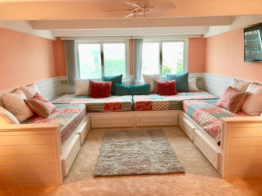 Custom built platform w 2 queens & 2 twin XLs. This room now serves as an additional family room for the kids.