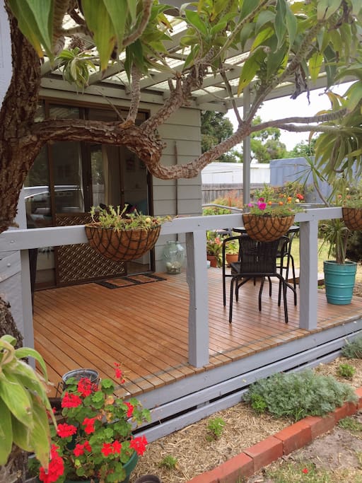 The deck has a separate and intimate setting to enjoy, surrounded by birds and a lush garden