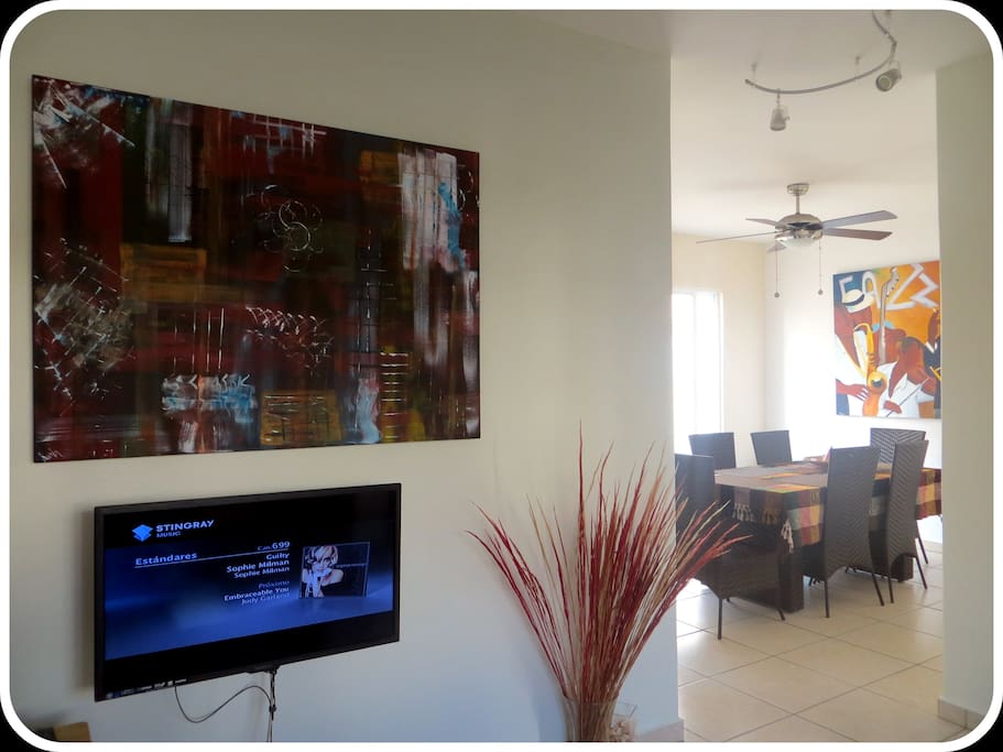 View from the entrance, into modern art by talented international painter Reine. And to the right modern dining room.